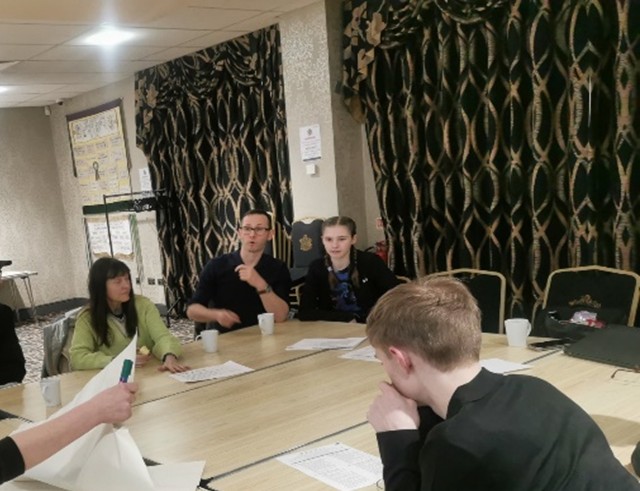 Guiding voices members sat at a table in discussion