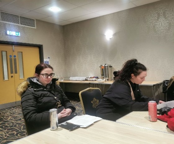 Two females sat at a table discussing priorities for smiles for miles
